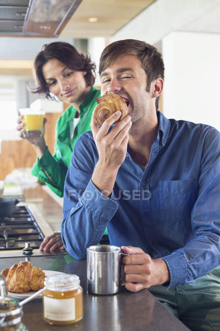 Coppia che fa colazione al bancone della cucina — Foto stock