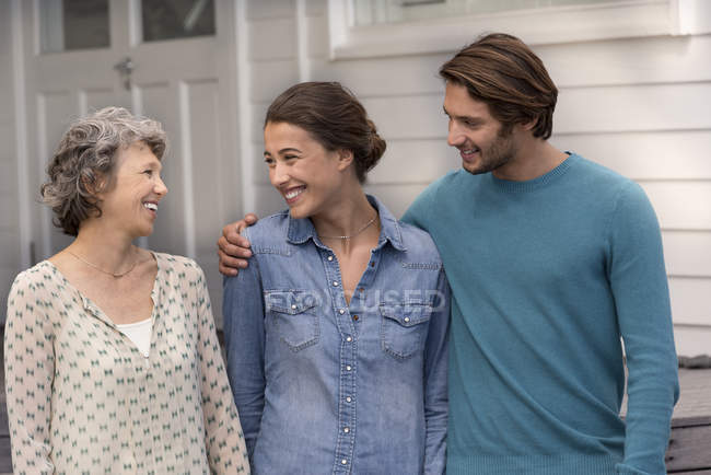 Smiling mature woman standing with young couple outdoors — Stock Photo