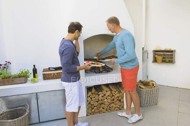 Two men cooking kebab at fireplace — Stock Photo