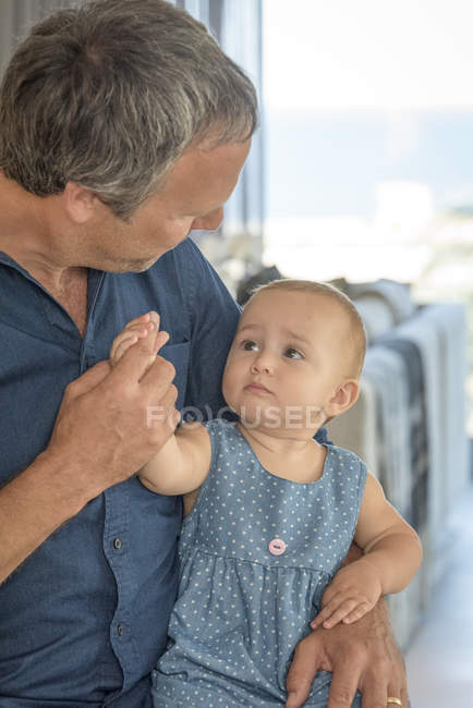 Primer plano del hombre maduro jugando con su hija pequeña - foto de stock