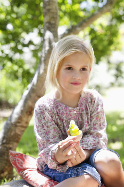Милая маленькая девочка держит игрушку в саду — стоковое фото