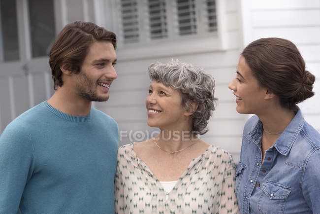Mulher madura feliz de pé com jovem casal ao ar livre — Fotografia de Stock