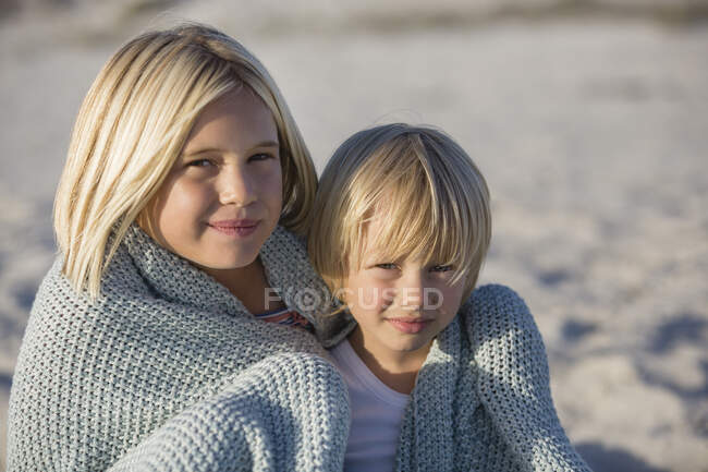 Close-up de um irmão e sua irmã na praia — Fotografia de Stock