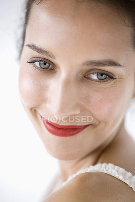 Retrato de mujer sonriente en maquillaje mirando hacia otro lado - foto de stock