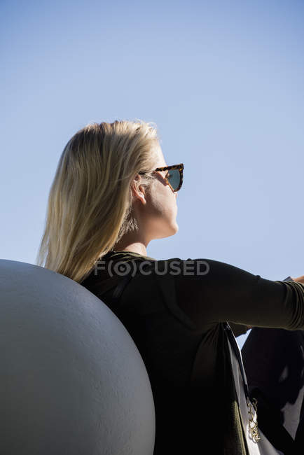 Blond young woman relaxing on chair outdoors — Stock Photo