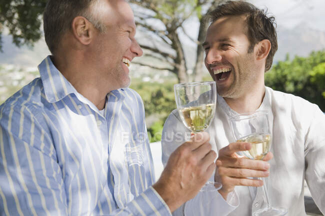 Dos amigos bebiendo vino blanco - foto de stock