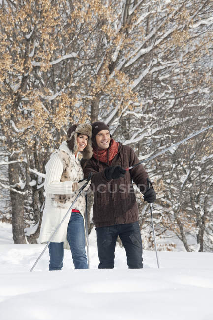 Молода пара катається на снігоступах в зимовому лісі — стокове фото