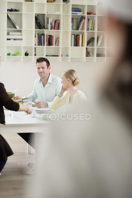 Happy family talking at dining table — Stock Photo