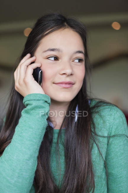 Крупним планом дівчина розмовляє по мобільному телефону і дивиться в сторону — стокове фото