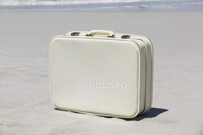 Складки валізи на пляжі, вибірковий акцент — стокове фото