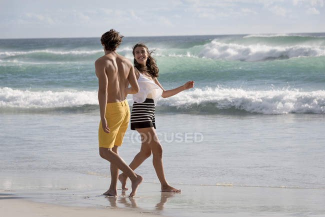 Happy cheerful young couple having on summer beach — Stock Photo
