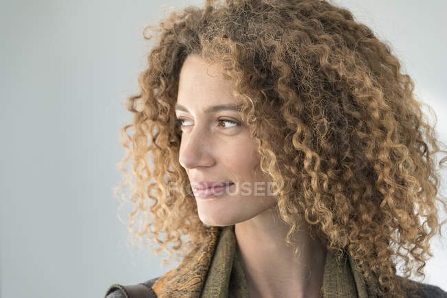Portrait of thoughtful happy woman with curly hair — Stock Photo