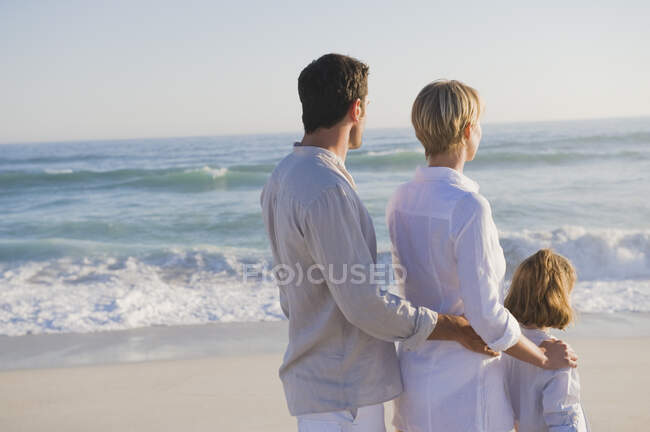 Семья, стоящая на пляже — стоковое фото