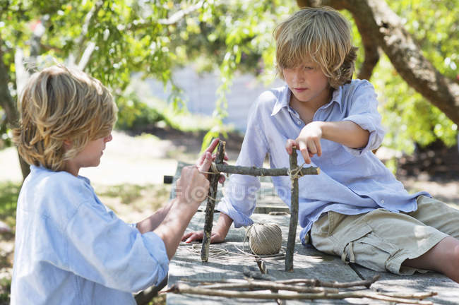 Дети делают раму из колючей древесины на открытом воздухе — стоковое фото