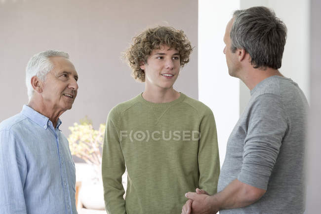 Glückliche Mehrgenerationenmänner Teenager-Junge spricht zu Hause — Stockfoto