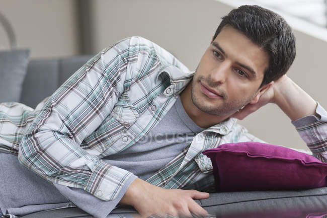 Entspannter Mann liegt auf Couch und denkt nach — Stockfoto