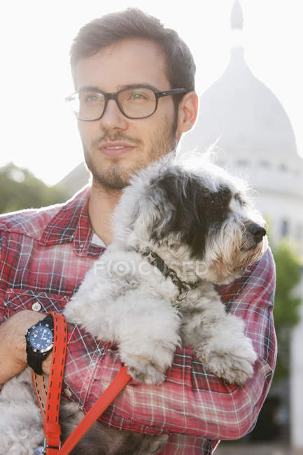 Uomo che porta cucciolo in città e distoglie lo sguardo — Foto stock