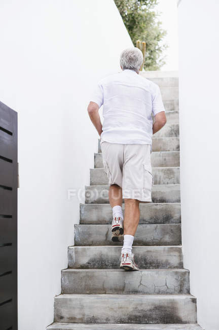 Senior man moving up steps outdoors — Stock Photo
