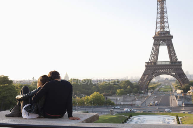 Pareja sentada junto a la Torre Eiffel de fondo, Jardins du Trocadero, París, Isla de Francia, Francia - foto de stock