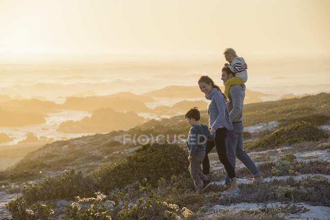 Family walking on beach at bright sunset — Stock Photo