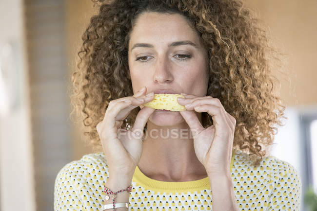 Primer plano de la mujer comiendo rebanada de piña fresca - foto de stock