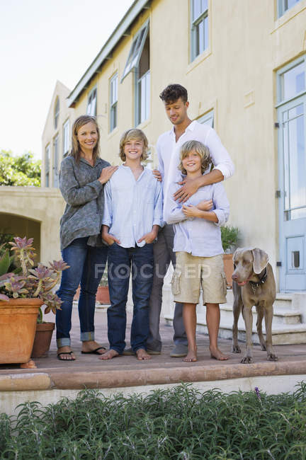Portrait of happy family having fun on backyard with dog — Stock Photo
