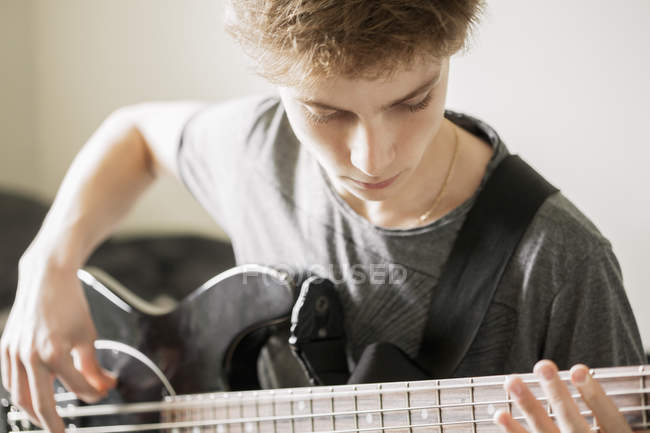 Хлопчик-підліток грає на гітарі, вибірковий фокус — стокове фото