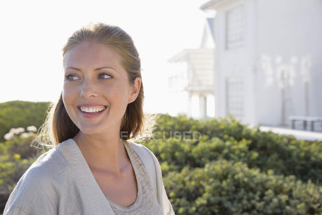 Крупним планом усміхнена елегантна жінка, що стоїть на відкритому повітрі — стокове фото