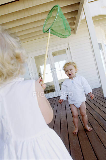 2 ребенка играют на деревянной террасе — стоковое фото