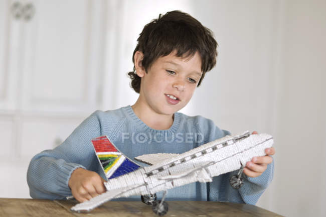 Kleiner Junge spielt zu Hause mit Modellflugzeug — Stockfoto