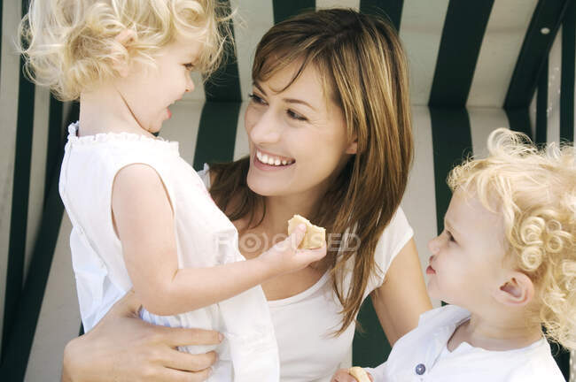 Mother and 2 children on a swing chair — Stock Photo