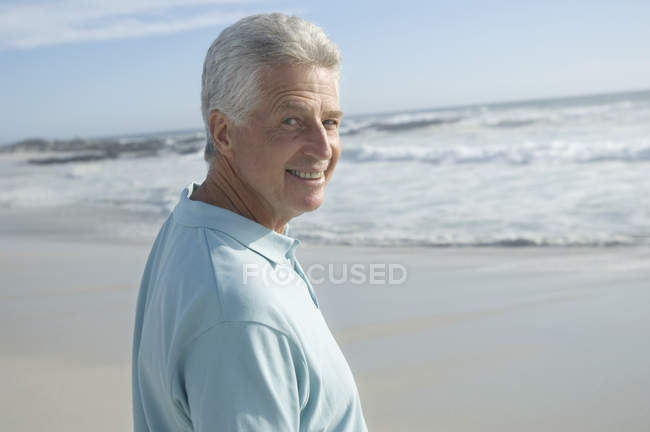 Портрет улыбающегося человека на песчаном пляже — стоковое фото