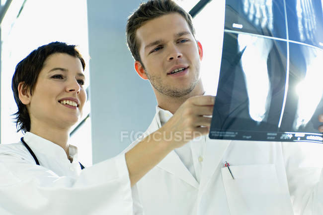 Крупный план двух врачей, изучающих рентгеновский отчет — стоковое фото