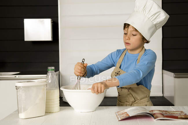 Мальчик делает торт — стоковое фото