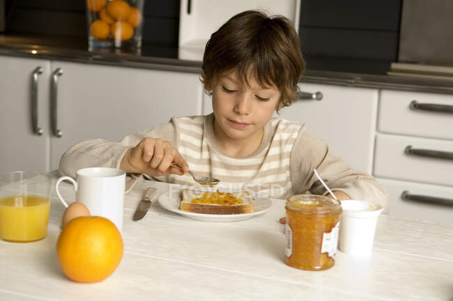 Niño desayunando en casa - foto de stock