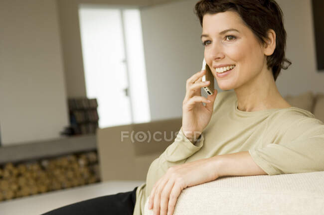 Metà donna adulta parlando su un telefono cellulare — Foto stock