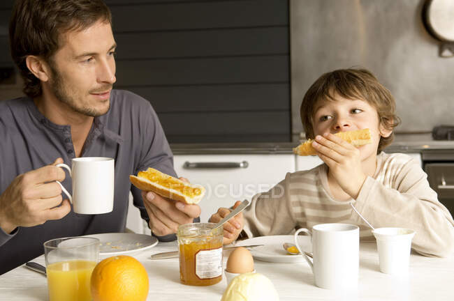 Homme d'âge mûr déjeunant avec son fils — Photo de stock