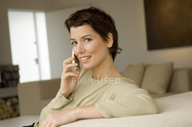 Retrato de una mujer adulta que habla por teléfono móvil - foto de stock