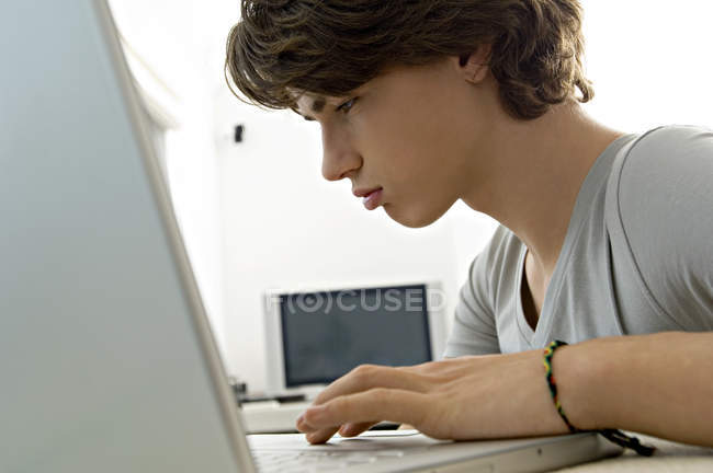 Крупним планом хлопчик-підліток використовує ноутбук — стокове фото