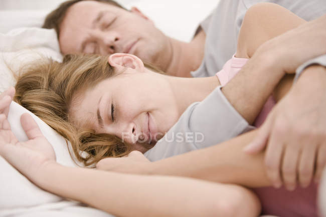 Close-up of happy romantic couple sleeping on bed — Stock Photo