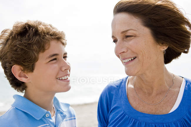 Mujer y nieto mirándose y sonriendo - foto de stock