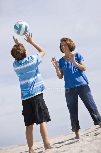 Женщина с внуком играет в пляжный волейбол — стоковое фото