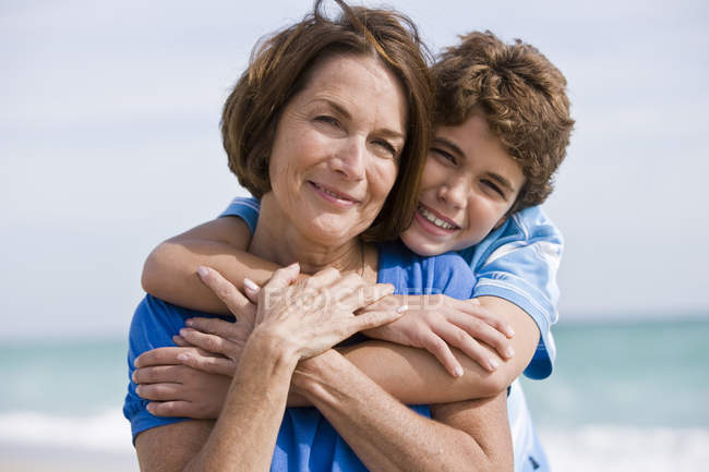 Щасливий хлопчик обіймає бабусю на відкритому повітрі — стокове фото