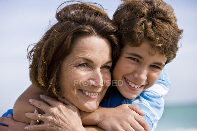 Счастливый мальчик обнимает бабушку на улице — стоковое фото