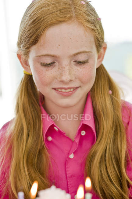 Close-up de menina de gengibre olhando para bolo de aniversário — Fotografia de Stock