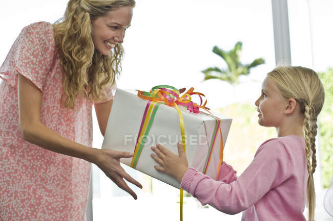 Дівчина дарує подарунок мамі — стокове фото