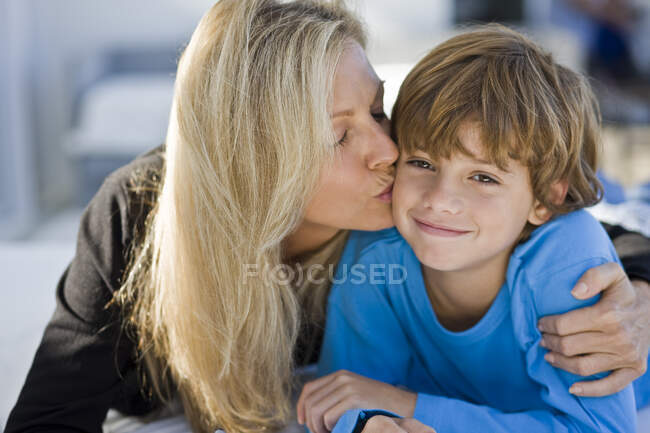Женщина целует своего сына — стоковое фото
