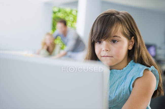 Focused little girl using laptop at home — Stock Photo