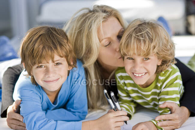 Портрет двух мальчиков, улыбающихся вместе с матерью — стоковое фото