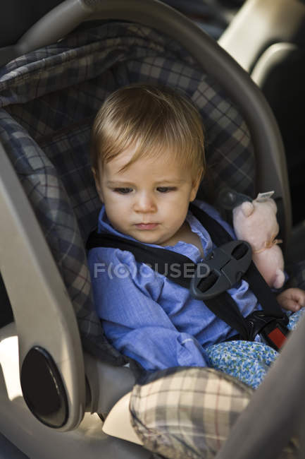 Menino pensativo sentado no assento do bebê — Fotografia de Stock